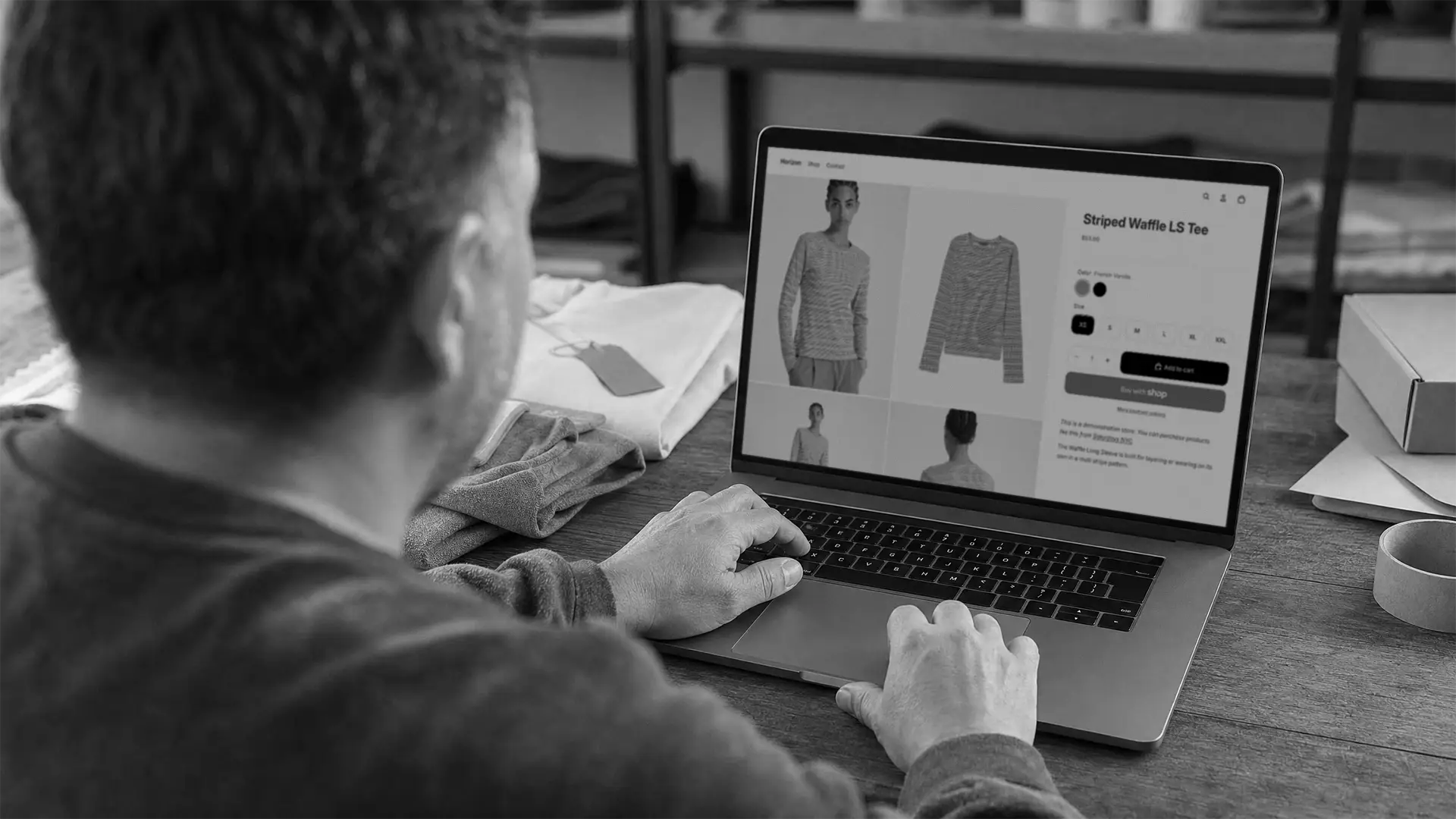 man viewing his shopify store on laptop in warehouse UNEO MEDIA